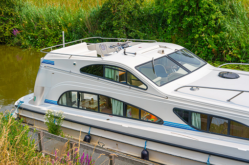 White And Red Houseboat Anchored In Sacramento River Near Old Public Dock