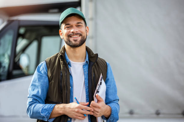 Happy confident male driver standing in front on his truck Happy confident male driver standing in front on his truck working class stock pictures, royalty-free photos & images