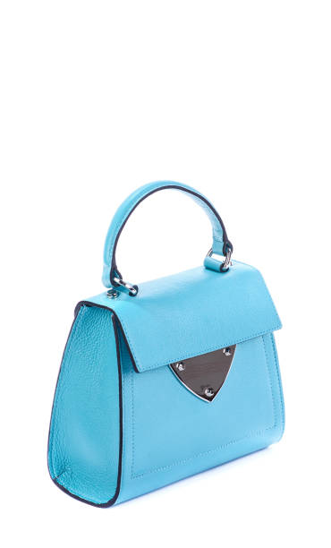 istock Trendy turquoise leather women's flap bag with top handle and silver accent and hardware on a white background with a zigzag pattern. Fashion blog. Discount, season sales. Retail, store, boutique. 1756252357