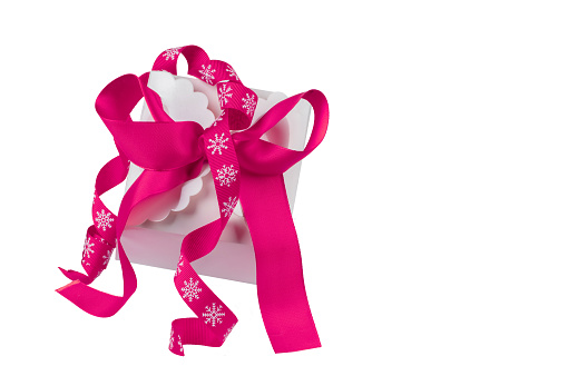 Christmas gift box with pink bow on white background.