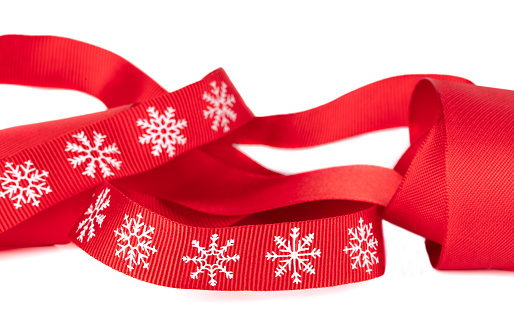 Christmas red ribbon with white snowflakes isolated.