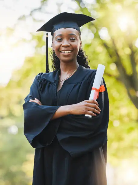 Photo of Graduate, diploma and portrait of black woman outdoor with arms crossed to celebrate success, education and college scholarship. Happy student, university graduation or achievement of certified award