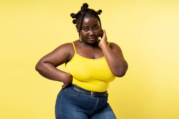istock Positive plus size model with stylish hairstyle looking at camera isolated on yellow background 1756302064
