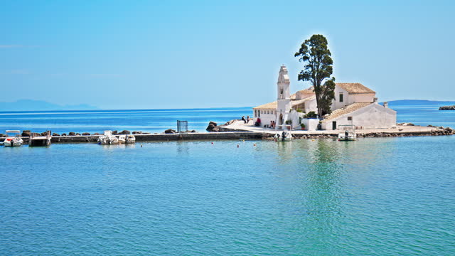 Holy Monastery of Panagia Vlacherna in Corfu, Greece surrounded by crystal blue water.