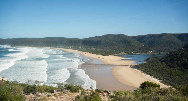 View of a long sandy beach on a scenic coastline at the ocean on sunny day in summer