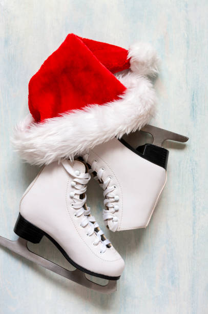 istock White figure skates and red Santa hat on the blue light background 1756316052