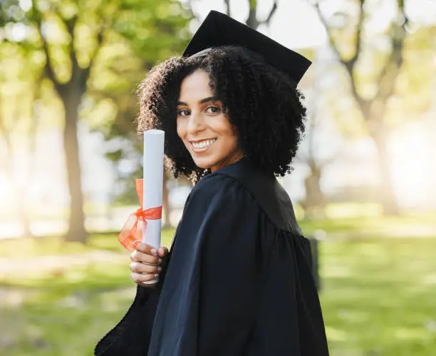 Photo of Graduation, portrait of woman and smile with diploma to celebrate event, education and college scholarship outdoor. Happy university graduate with certificate, award and certified achievement in park