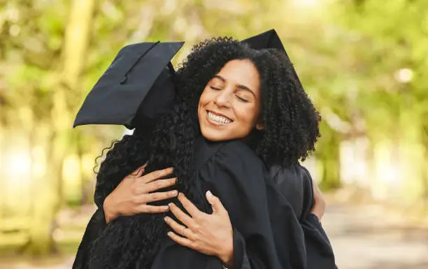 Photo of Support, graduation and women outdoor, hug and happiness with celebration, diploma and degree. People, students and friends embrace, education and outside with excellence, achievement and university