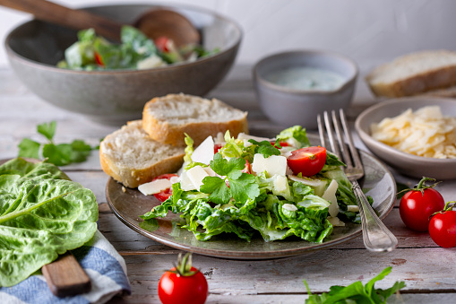 Green salad with tomatoes, bread and parmesan cheese