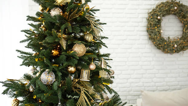 istock Christmas tree in the beautiful interior. Decorated Christmas tree on soft yellow lights with bokeh effect background. Festive composition with fir sparkling backdrop, new year decorations. Close up, copy space 1756321605