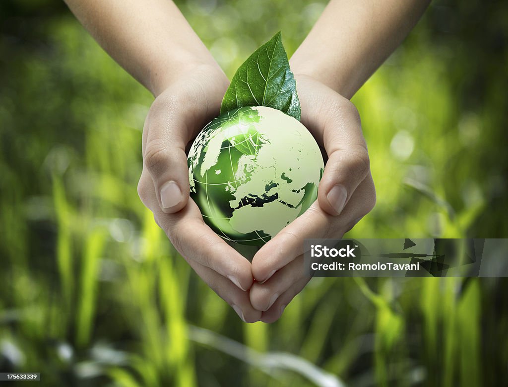 green world in the heart hand glass globe in hands - green grass background Globe - Navigational Equipment Stock Photo