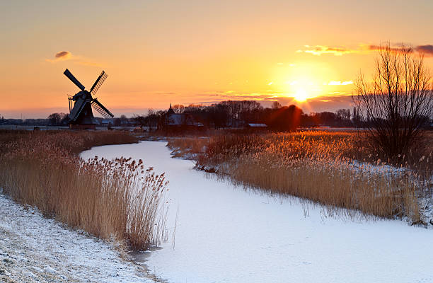 日の出で冬の風車 - netherlands windmill farm farmhouse ストックフォトと画像