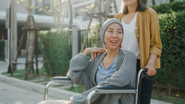 Young Asian people taking care health help cancer patients sitting in wheelchair outside home. Healthcare. Young Asian people taking care health help cancer patients sitting in wheelchair outside home. Healthcare concept. cancer illness stock pictures, royalty-free photos & images