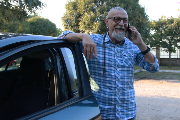 istock Senior businessman close car using smart phone 1756389372