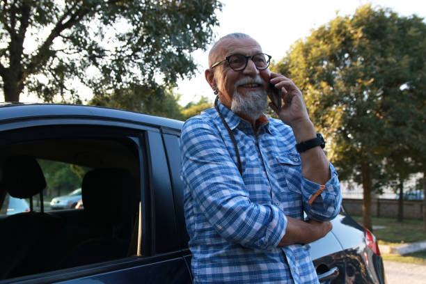 istock Senior businessman close car using smart phone 1756389379