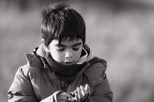 A picture of my son last winter while we were on holiday in Cornwall,  a black and white portrait shot. He was wearing a few layers of winter clothes.