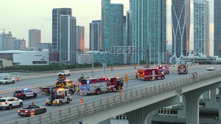 Top view of first responders at car accident site in Miami, Florida. Emergency services personnel helping victims of car crash on city street in USA