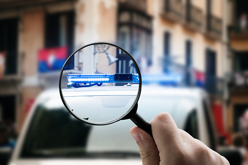 A magnifying glass focusing on police car lights