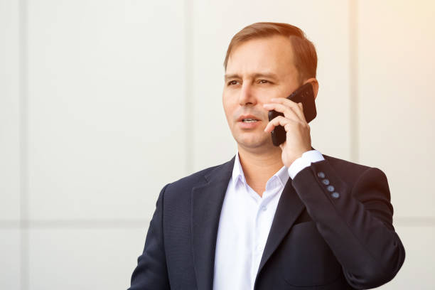istock Confident businessman in suit talks concerned on phone 1756418680