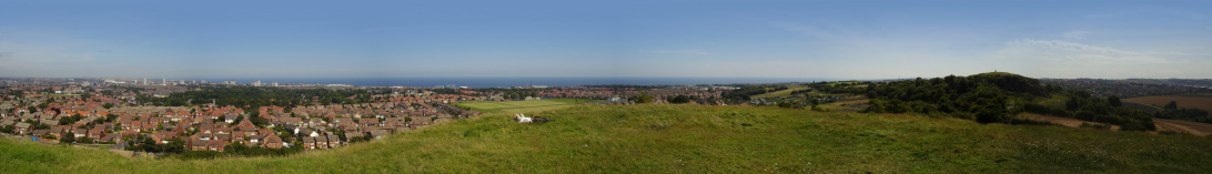 Sunderland, Tyne and Wear panorama view from Tunstall Hill. The city centre, sea and the Stadium of Light can be seen in the distance. Cyclist relaxing on the top of the hill.
