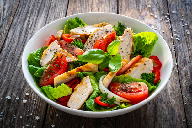 istock Caesar style salad  - fresh vegetables with grilled sliced chicken breast on wooden table 1756429975