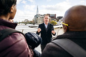 London tour guide talking to tourists by River Thames