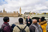 British tour guide talking to tourists by Houses of Parliament