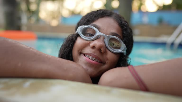 Portrait of a girl leaning at the edge of the pool