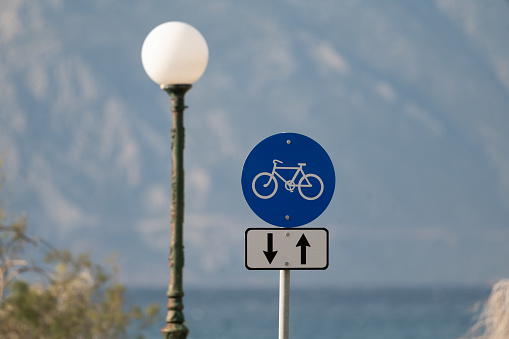 Sign of a cycle path on a riverside road