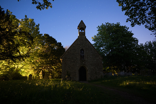 Bathed in the ethereal glow of the moonlight, an English church stands as a testament to both architectural grandeur and spiritual serenity. This captivating image captures the sacred beauty of the scene, with the softly lit windows and intricate stonework of the church creating a sense of tranquility and reverence.