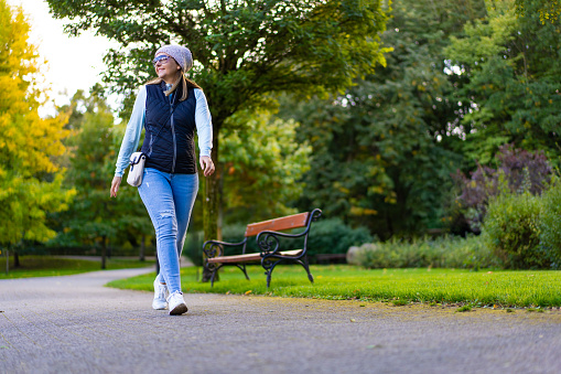 Beautiful mid-adult woman walking in city park