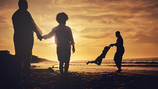 Silhouette, family and on beach for holiday, quality time and happiness on sand, weekend break and cheerful. Love, parents and children on summer vacation, sunset or bonding together, loving or relax