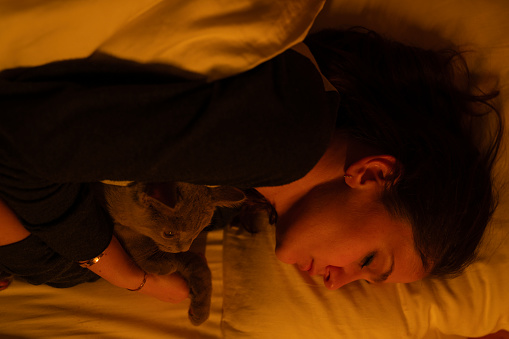 Young beautiful woman sleeping in her bed in late at night. Real life photography.