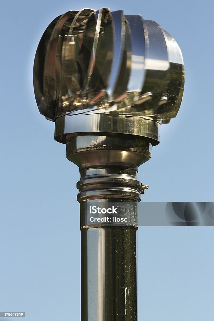 Steel rotor on top of a chimneypot with sky background Blue Stock Photo