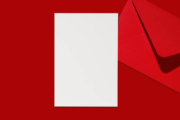 istock Christmas letter mockup. Blank white empty page and red paper envelope on red background. Postcard, greetings and thank you card template. 1756485690