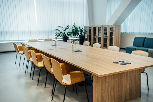 Large group of office chairs and conference table in meeting room.