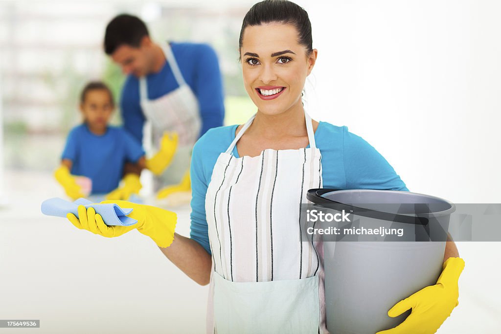 young woman with cleaning tools beautiful young woman with cleaning tools in front of family Adult Stock Photo