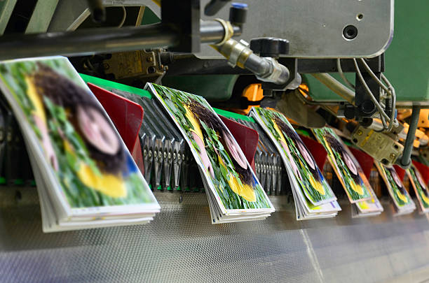Printing offset conveying plant Brochure and magazine stitching process. Close-up of the  offset conveying process of a full-automatic stitching unit. magazine publication photos stock pictures, royalty-free photos & images