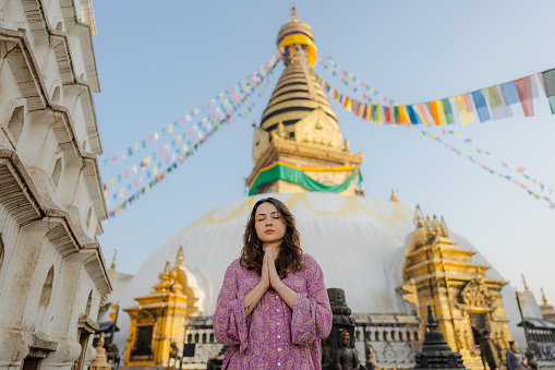 Serene woman  doing tree pose on the background of stupa