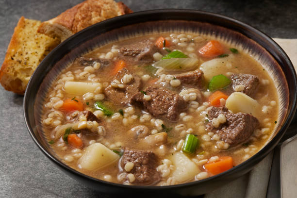 Beef and Barley Vegetable soup Beef and Barley, Vegetable Soup with Mushrooms, Onions, Potatoes, Carrots, Celery and Garlic Bread steak-and-ale stock pictures, royalty-free photos & images
