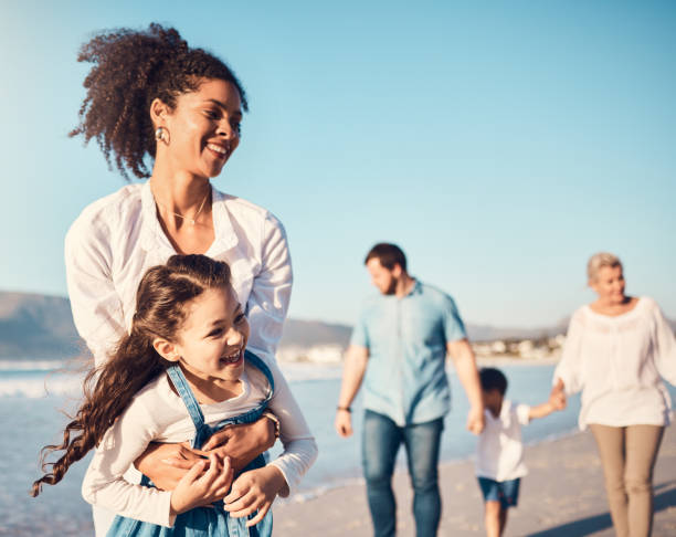 mutter, kind und spielen im freien am strand im familienurlaub, urlaub oder abenteuer im sommer. aufgeregtes junges mädchen kind und eine frau mit lustiger energie, glück und liebe oder qualitätszeit auf see - couple two parent family beach loving stock-fotos und bilder