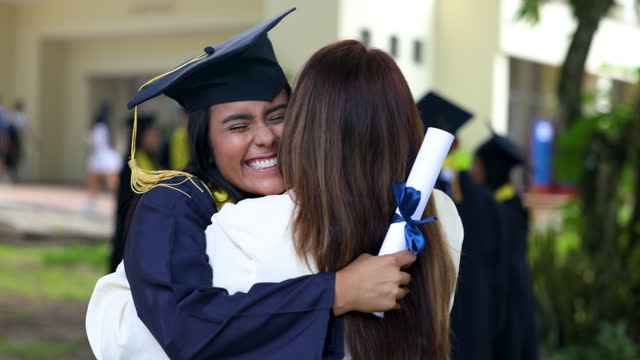 Proud and excited young woman hugging  mom after the university graduation ceremony