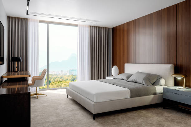 Modern Luxury Hotel Room A modern bedroom design with a spacious double bed flanked by stylish nightstands and lamps.
The room is illuminated by a large window, presenting a natural scenic view.
The floor is adorned with a light-colored rug, while the walls and cabinets are clad in wooden finishes.
The overall color palette of the room exudes warm tones, depicting a luxurious and comfortable ambiance hotel window view stock pictures, royalty-free photos & images