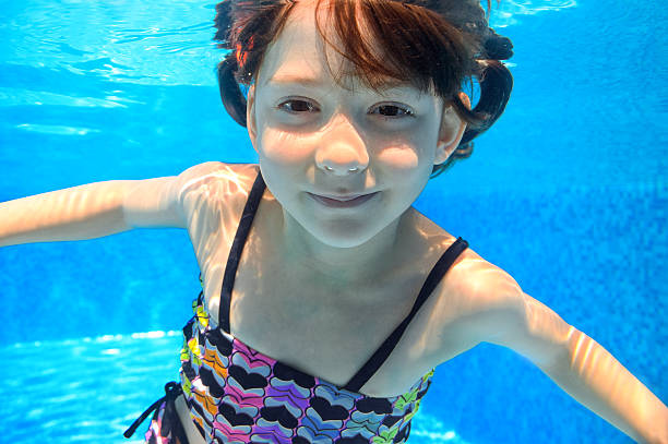 istock Happy active child swims underwater in pool 175656312