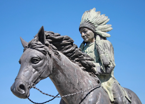 Statue of an Indian or native American that riding a horse