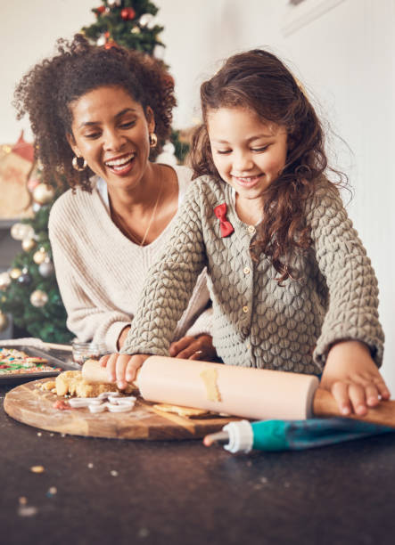 Kid, baker and mother on christmas with happiness for teaching on kitchen counter for lunch. Smile, child and learning with cookies with parent for festive season in home with bond or development.