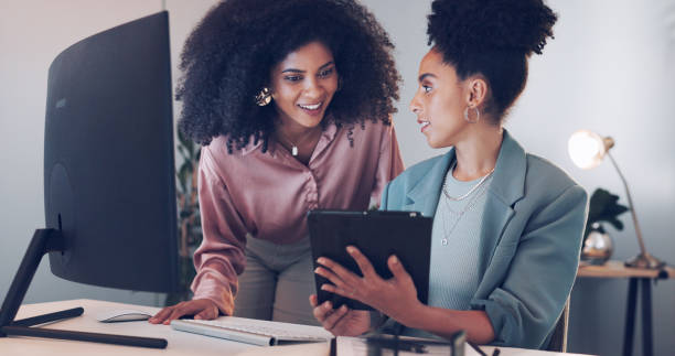 istock Team, mentor and computer or tablet for marketing project, social media planning and internship advice or support. Editor, manager or business women on desktop for editing or digital data at night 1756585771