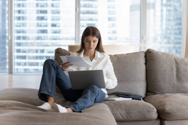 istock Busy woman sitting on sofa working or studying use laptop 1756587418