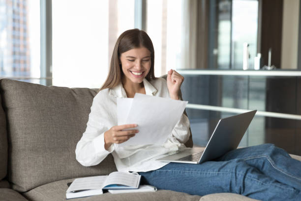 istock Excited woman sits on sofa read paper notice feels happy 1756601062