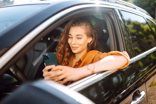 istock Beautiful woman driver in a car with a phone in her hands. 1756629068